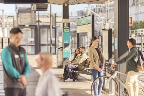 People at a busy train stop.